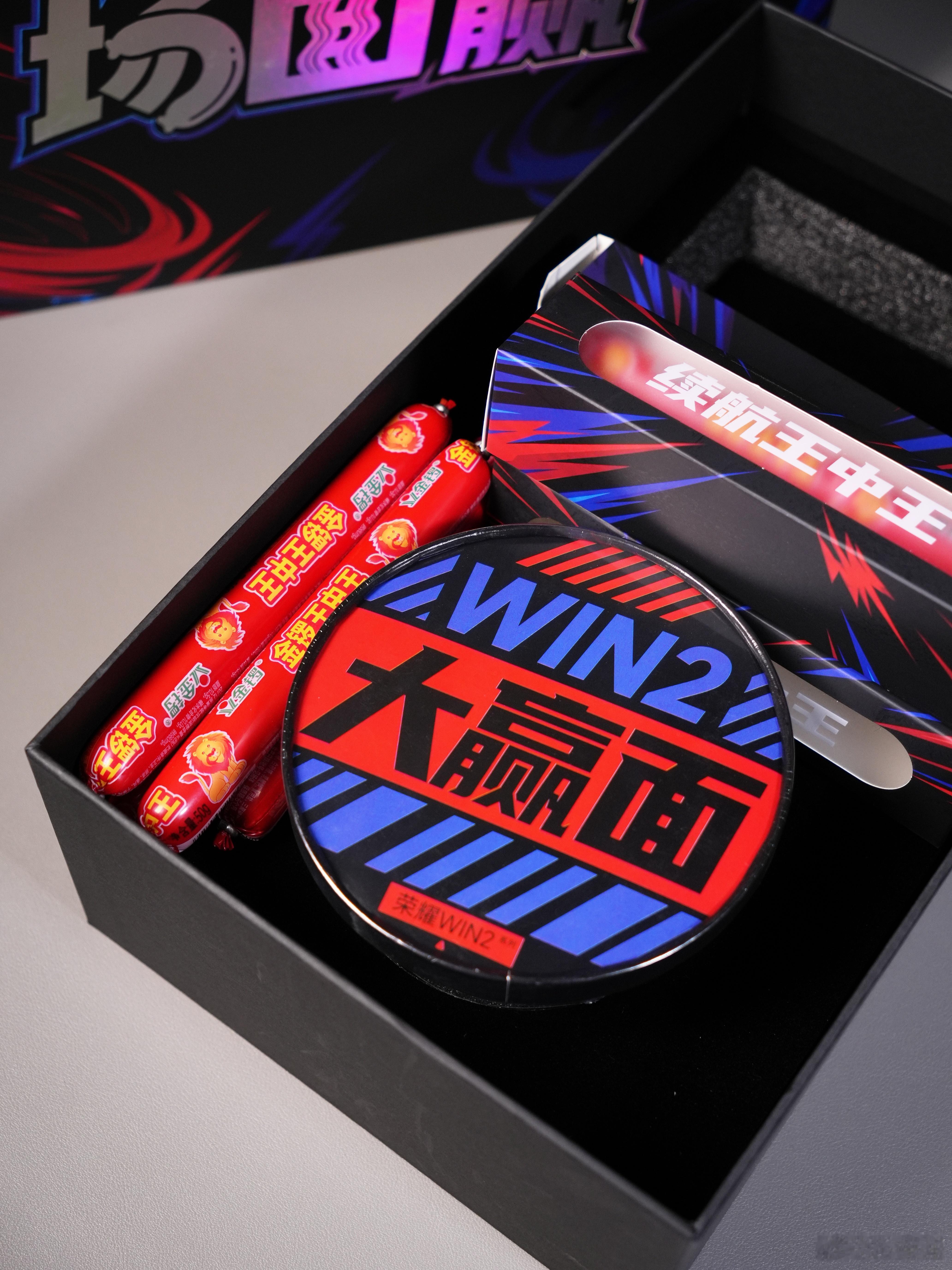 荣耀是会整活的，这个发布会邀请函有点意思，一桶“大赢面”泡面搭配王中王火腿肠（共有16根，有想吃肠的嘛😋）四盒肠分别对应性能、散热、显示、续航四大卖点！
-
这次的荣耀Win2系列共有三个版本，分别的排序是荣耀Win2＞荣耀Win RT2＞荣耀Win Turbo2，其中荣耀Win2搭载骁龙8EE6旗舰芯片+10100mAh ​