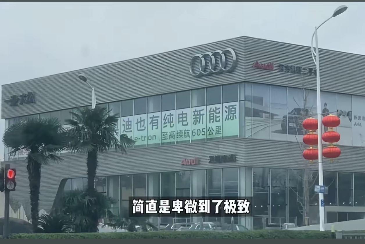 昔日加价排队提车，今天挂横幅喊“我也有”。奥迪4S店这条横幅，硬生生把传统豪车的体面按在地上摩擦。

“奥迪也有纯电新能源，奥迪e-tron 至高续航605公里”。

品一品，这句文案藏着多少憋屈？

当年燃油车时代，奥迪A6L、Q5L是什么地位？官车代表、科技标杆，甚至要加价排队。那时候的奥迪需要