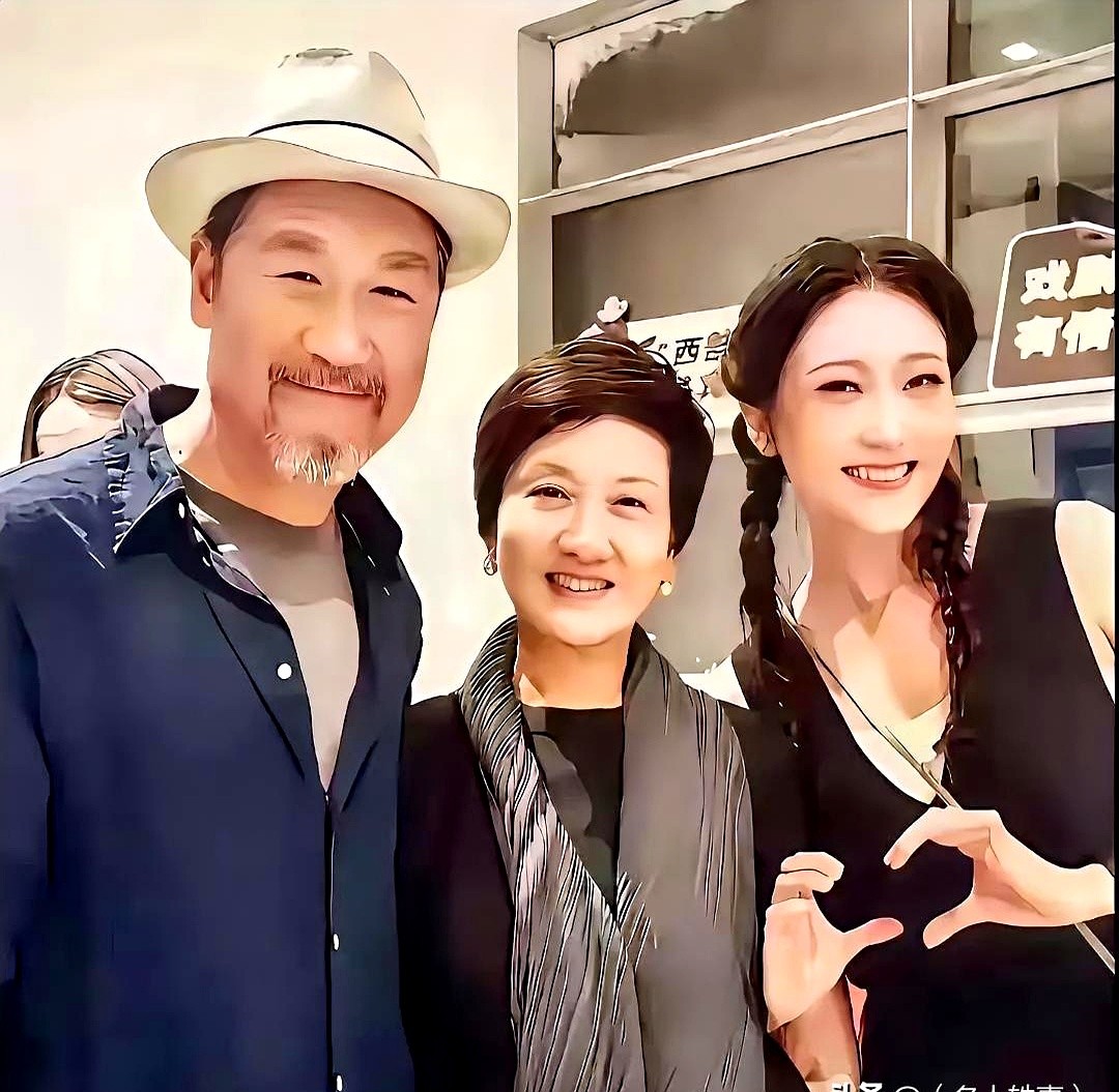 张国立花白胡须配着黑礼帽，一旁的邓婕还是那副笑眯眯的模样。

镜头前，这对老两口硬是把中间的位置让给了一个穿戏服的年轻人。快门按下，三人笑得像街坊邻居唠家常。

一场没多少流量的戏曲活动，硬是被这两位定海神针撑起了场面。当年满大街溜达的皇上和宜妃，如今头发白了，身段却放得更低了。

张国立伸手拍了拍
