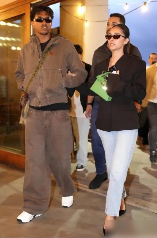 19岁的亚马尔，牵着女友的手往那一站，直接把派对变成了主场。
这姑娘叫伊内斯·加西亚，两人同框甜得发腻，穿搭一个松弛一个利落，镜头全被吸过去了。
但真正狠的是他球场上的账本：本赛季13场，12球8助攻，场均造1.5球。欧冠差姆巴佩的20岁前纪录，只差1个。
身价2.2亿欧，西班牙第一。他放话：