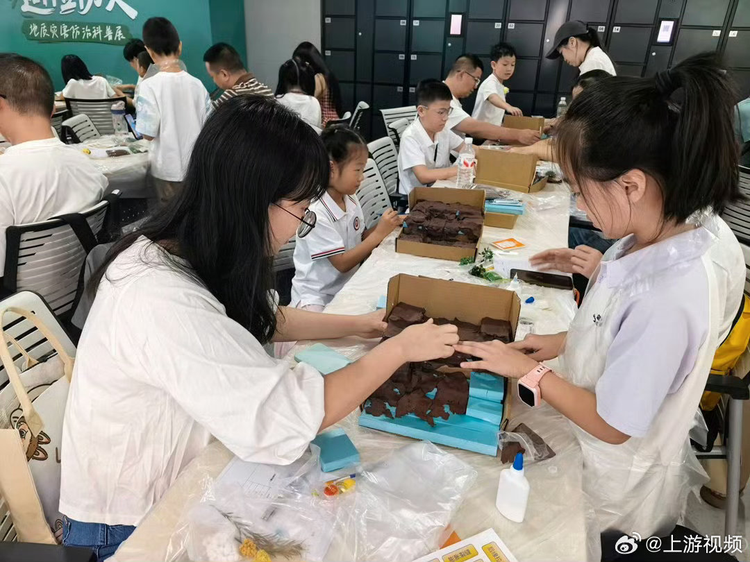 #重庆小朋友用橡皮泥捏滑坡模型学避险#【群防群治·百日攻坚｜科普展上，小朋友用橡皮泥捏“滑坡”模型学避险】#群防群治百日攻坚# 
9月12日，重庆市规划展览馆内，一群孩子围坐在长桌旁，手里捏着棕褐色的橡皮泥，往蓝色纸板搭起的坡面上堆。坡面越堆越高，“山石”开始松动，坡面一片狼藉——这不是手 ​
