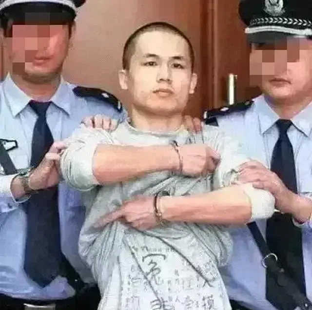 2013年，深圳市一民警李才坤被判死刑，在面对记者镜头时，他突然伸出被拷住的双手，猛得掀起自己的衣服，只见衣服上赫然写着“喊冤”两个大字！

2013年10月29日，深圳市中级人民法院一审宣判李才坤故意杀人案。

这里的“死刑”是死刑缓期二年执行，案件后来经过上诉，广东高院维持了原判。

镜头里，是