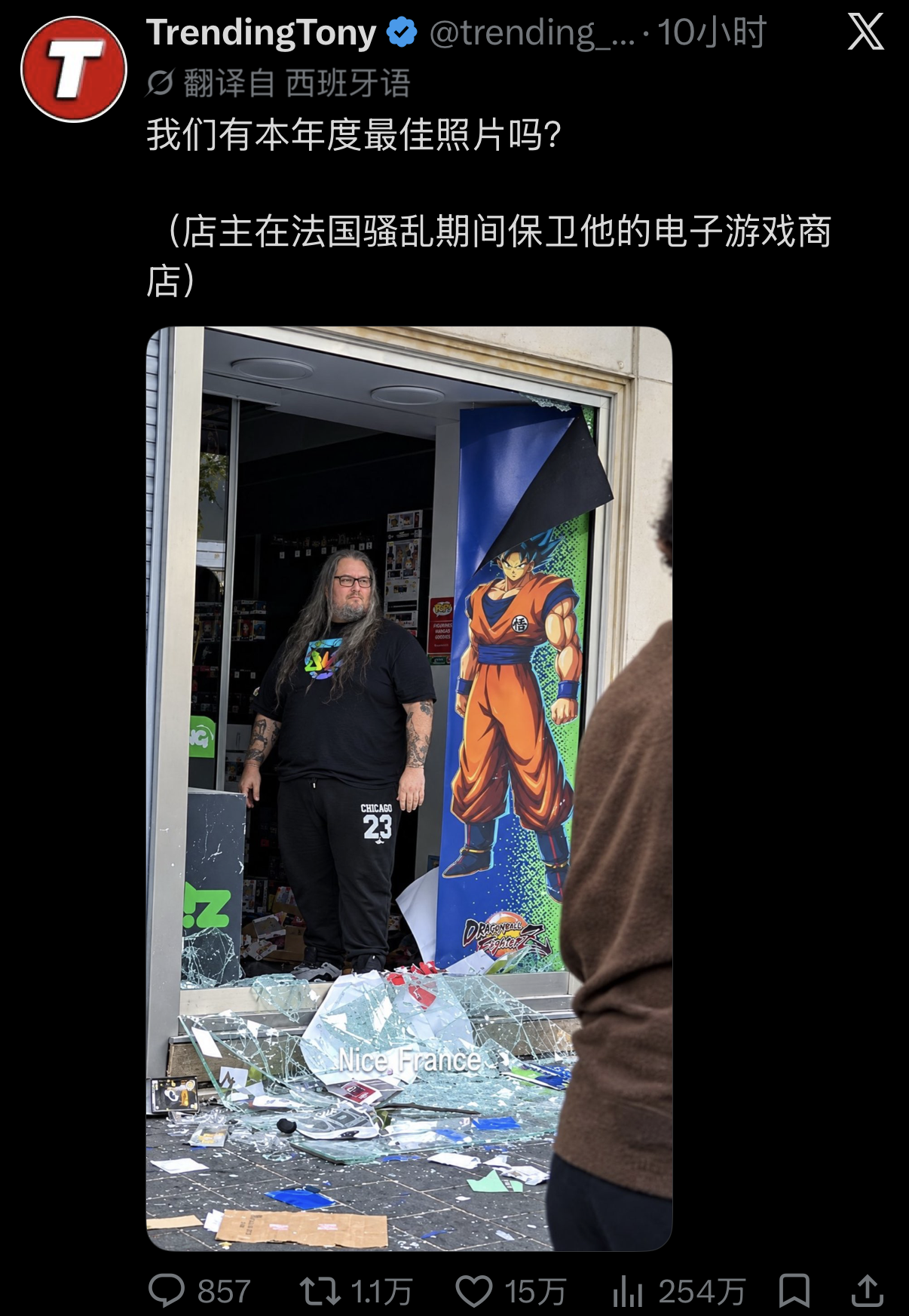法国尼斯街头，遍地玻璃碎片折射出刺眼的光，但比这更刺眼的是一家被砸毁的游戏动漫店门前站着的那个人。

满臂纹身、长发披肩、身材魁梧好似从游戏里走出的终极 Boss 店主，神情冷峻地立在破碎的门框中央。

先把这张照片的底子摆出来。照片里的人是皮埃尔，尼斯让·梅德桑大道上Micromania游戏店的店