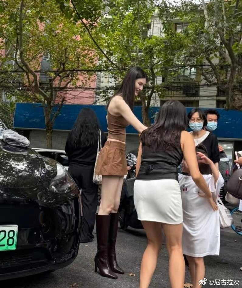 上海街头偶遇何穗，一眼就能感受到超模和普通人之间的差距。
又高又白，简单的吊带短裙加长筒靴，走在街上自带大片氛围感。
有人说这是天生优势，身高肤色很难复制；
也有人说，模特身上最难得的，是长期保持下来的体态。
同样一套衣服，挺拔舒展的姿态，完全是不一样的效果。
你觉得氛围感更多来自天 ​