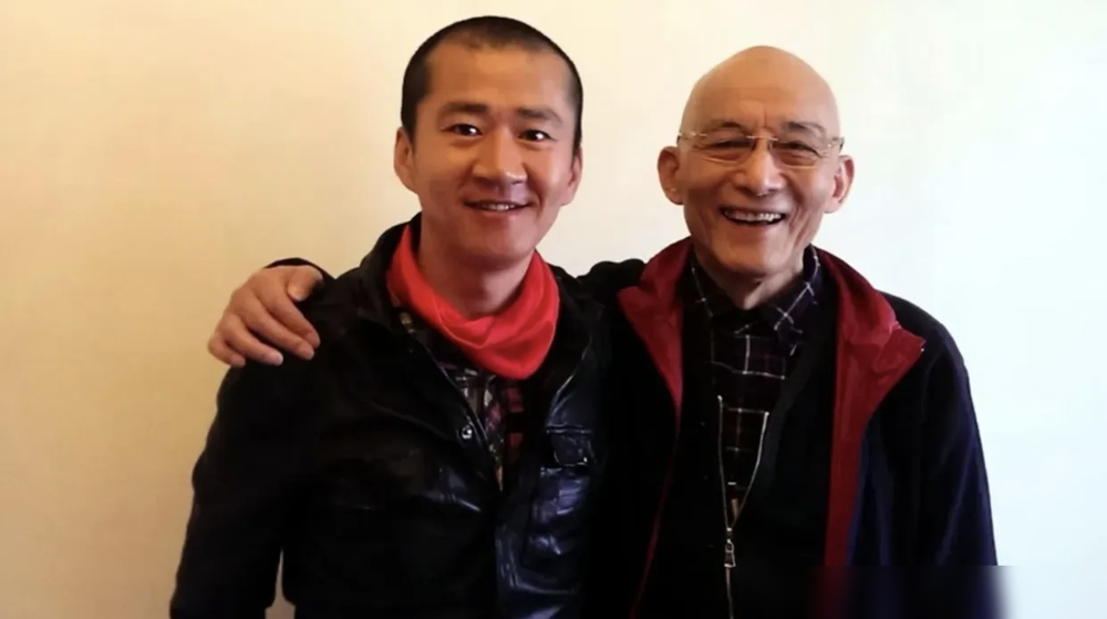 91岁的游本昌颤巍巍站上台，开口第一句就让新郎李嘉明绷不住了。
他说，孩子，十九年前你蹲在片场角落里啃冷馒头，我就知道你行。
李嘉明哭得像个孩子。2005年那会儿，他还是个没戏拍的穷小子，是游本昌手把手教他走位、抠台词。没地方住，老爷子家里给他留了间房。李嘉明说过，老爷子要是走了，跟他亲爹走了一