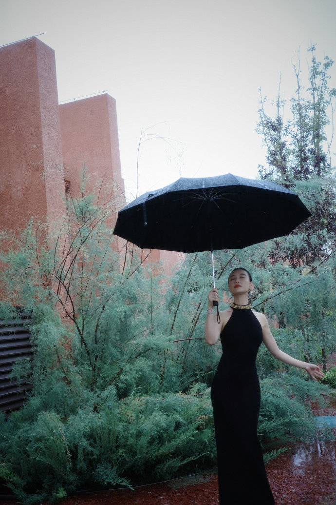 烟雨黑裙｜倪妮雨中大片，清冷氛围感拉满
细雨绵绵的户外，薄雾笼罩周遭，倪妮这组雨中写真，没有刻意的摆拍痕迹，仅凭穿搭气质和环境氛围，拍出了难得的高级故事感。素雅静谧的雨天场景，衬得她整个人清冷又温柔，气质格外独特。
她身穿一袭黑色挂脖鱼尾长裙，干净的挂脖版型，大方露出优越的肩颈线条，体态舒展又优雅。