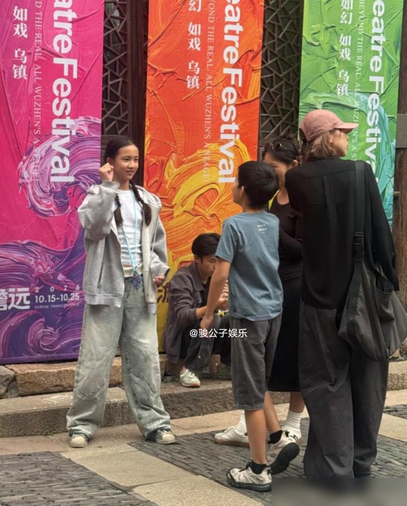 黄磊二女儿在乌镇被拍到了，网友第一反应全是：这不就是黄磊戴了假发？
12岁的黄少艾，两条麻花辫，一身休闲装，往那一站，眉眼活脱脱复刻了年轻版黄磊。评论区直接炸了，说她是“女版长发黄磊”，还有人翻出黄磊年轻时照片对比，越看越像。
再看他家大女儿黄多多，20岁，站黄磊旁边当翻译，一口英文流利得不行，