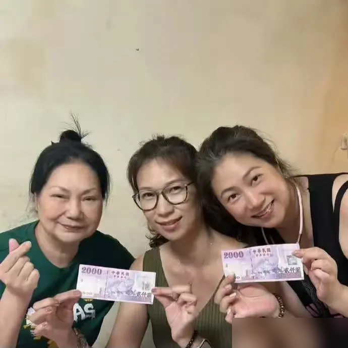 染黑发，盘起头，拿着两千块台币比爱心，S妈终于出来了。
七个多月没公开露面，中秋节被娘家人硬拉出来烤肉。表妹发文说，姑姑愿意走出来，大家就安心了。照片里她脸有点肿，但笑得出来，状态是真的松了。
可热闹是别人的。小S一家在伦敦玩，具俊晔连影子都没有。那栋住了几十年的豪宅，登记在大S名下，S妈不是第