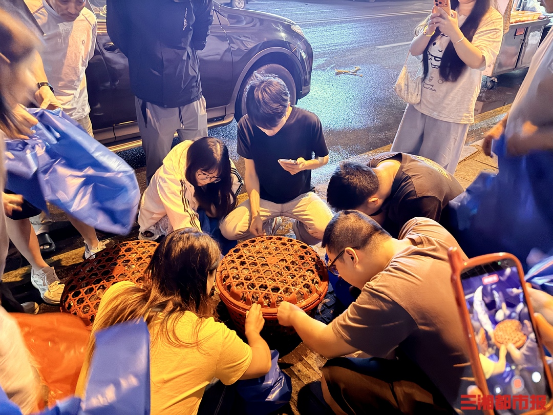 凌晨一点的长沙，酒吧还没散场，最热闹的地方已经换成了海鲜市场。
地方在马王堆海鲜水产批发市场。冷链车刚停下，一筐筐梭子蟹还带着海水，三四十个年轻人立刻围上去，一手拎袋子，一手按亮手机计算器。
拼法不复杂。市场按筐卖，一筐52斤，凑够人手就开拼。9月17日夜里，专程赶来的周女士在现场拉了一群陌生人加群