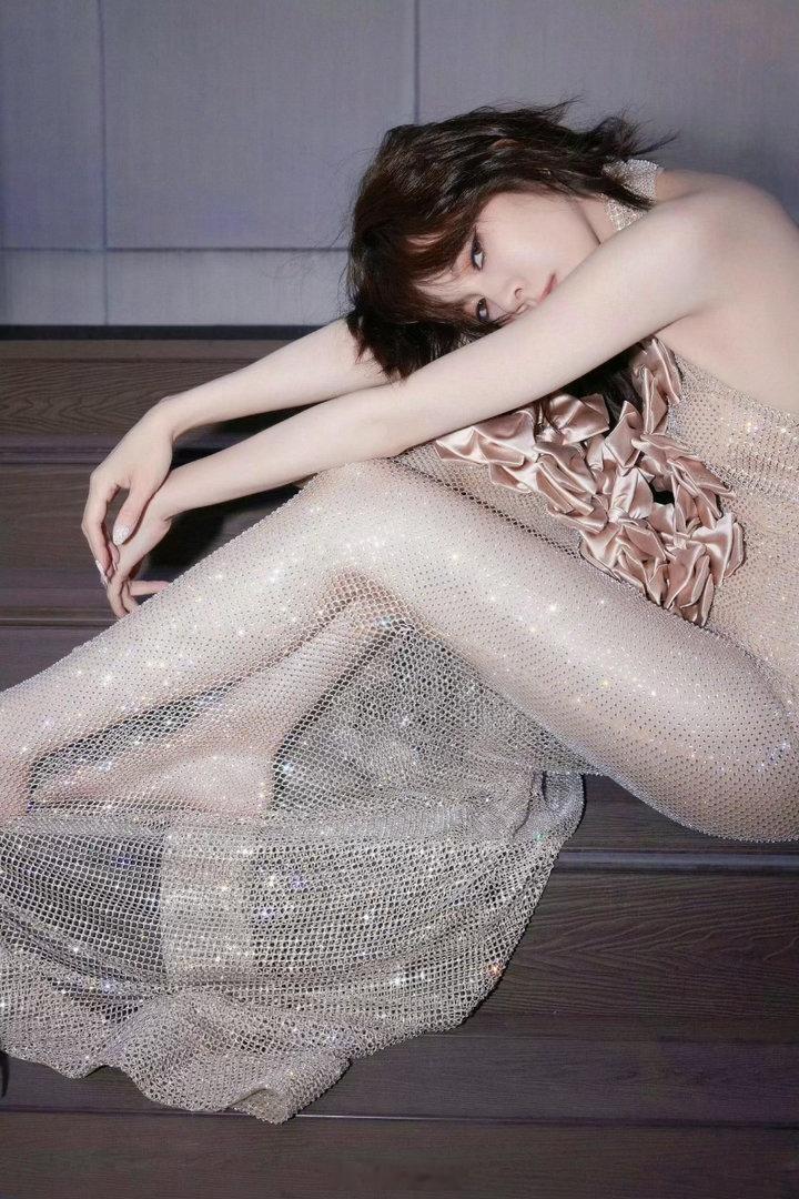 挂脖闪钻长裙缀满立体缎面蝴蝶结，细密碎钻随光影闪烁。逆光之下身形舒展，发丝轻扬，自带耀眼又妩媚的氛围感。
宋妍霏