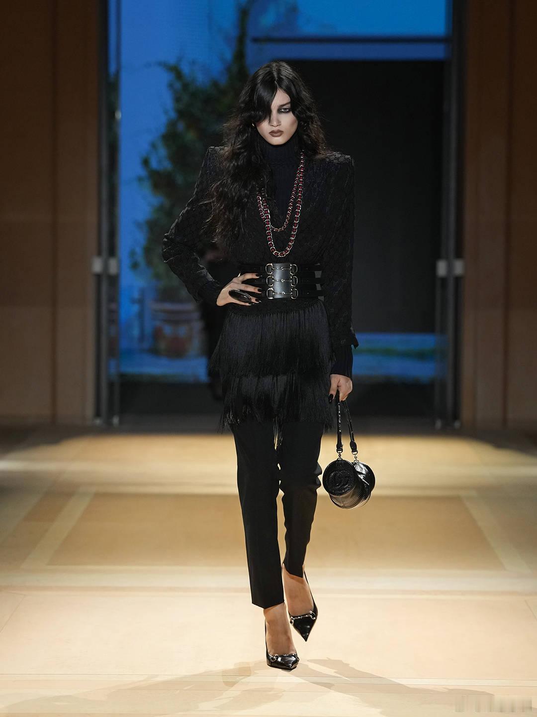 #GucciTheStoreShow#延续古驰马术基因的核心象征，3X腰封式腰带收束一系列的“新浪漫主义”造型，利落肩线的衬衫搭配铅笔管裤或格纹半身裙，叠加多层珠宝，尽释现代女性的优雅魅力。点击