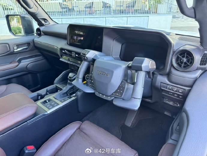 来看看丰田的 NEO Steer 手控转向系统，一个方向盘（真的很帅）后面的拨杆还集成了油门和刹车，推出的目的主要是方便下肢障碍人群驾驶。

#42how##丰田# ​