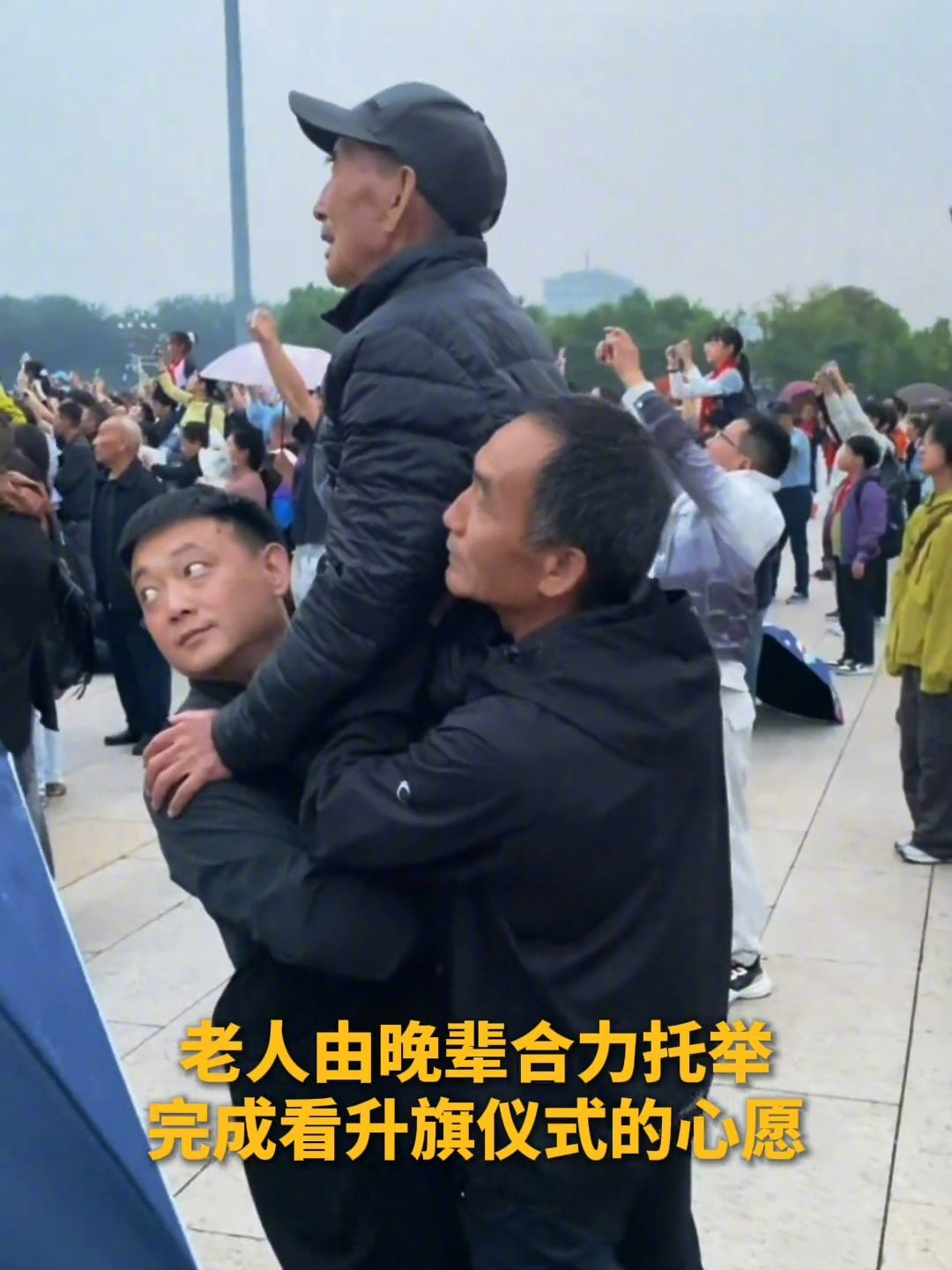 #晚辈合力托举老人看升国旗# 刷到那段视频的时候我正挤早高峰地铁，一眼就红了。

天安门广场看升旗，人多，前排全是高高的脑袋。一位坐轮椅的老人被家人架起来，几个年轻人一左一右托着胳膊，后面还有人扶着腰，把人稳稳抬过头顶。老人就那么看着旗慢慢上去，手一直攥着扶手。

我留意到托举的那几位 ​