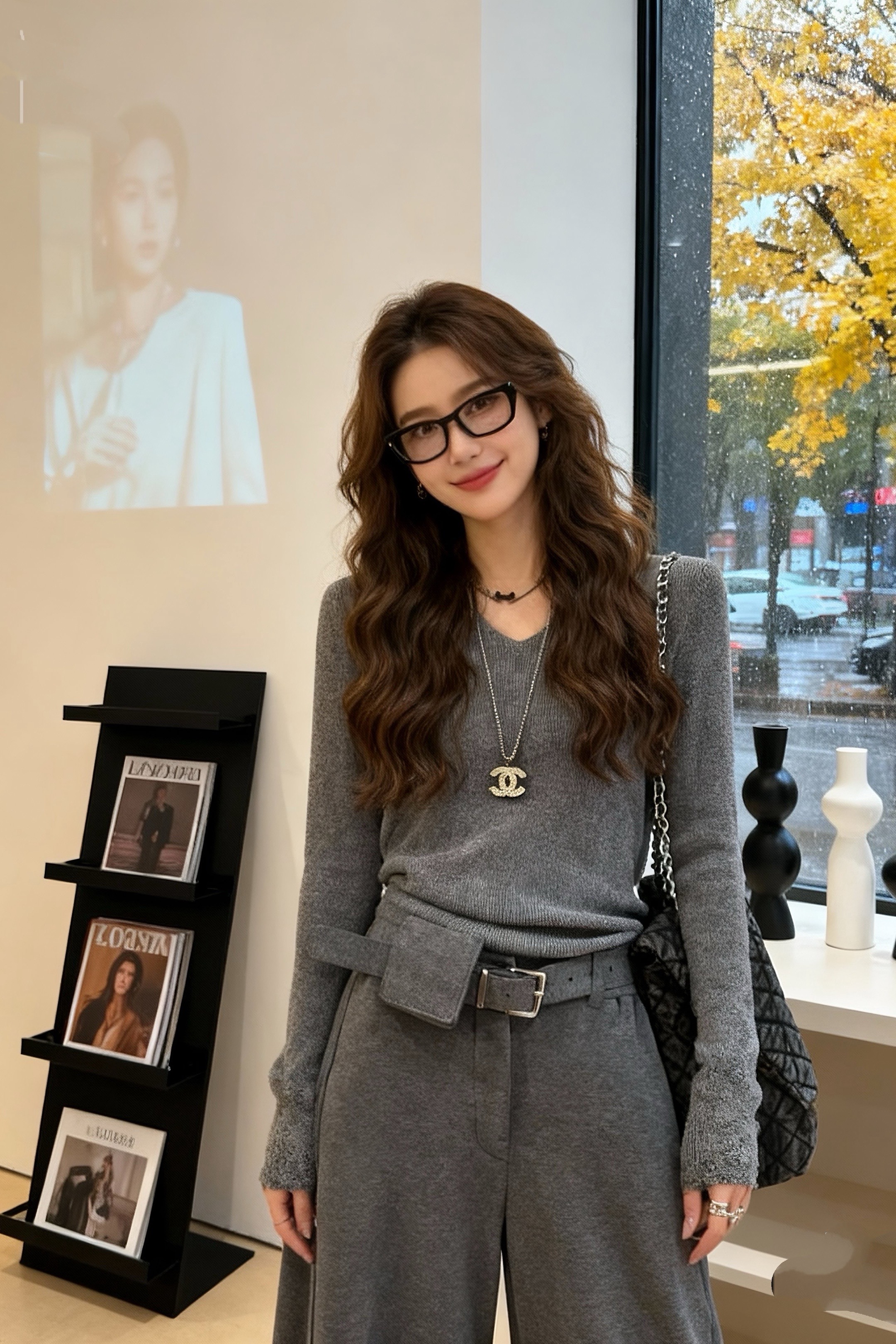 模特高颜值，亚洲美女长头发波浪，站在装饰摆有黑色杂志架与简约黑白色摆件...