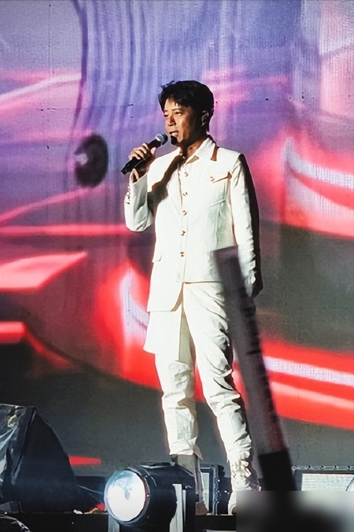 3万人的演唱会，压轴大咖李克勤迟到2小时，一个素人观众竟被导演从台下拉上台救场。
更绝的是，这哥们儿没提词器，没彩排，硬是凭着肌肉记忆，连干了近20首歌，把现场撑了两个小时，从Beyond唱到任贤齐，从没怯过场。
要知道，他之前最大的场子也就五六千人，这次是自费买票来看偶像的，结果自己成了主角。
