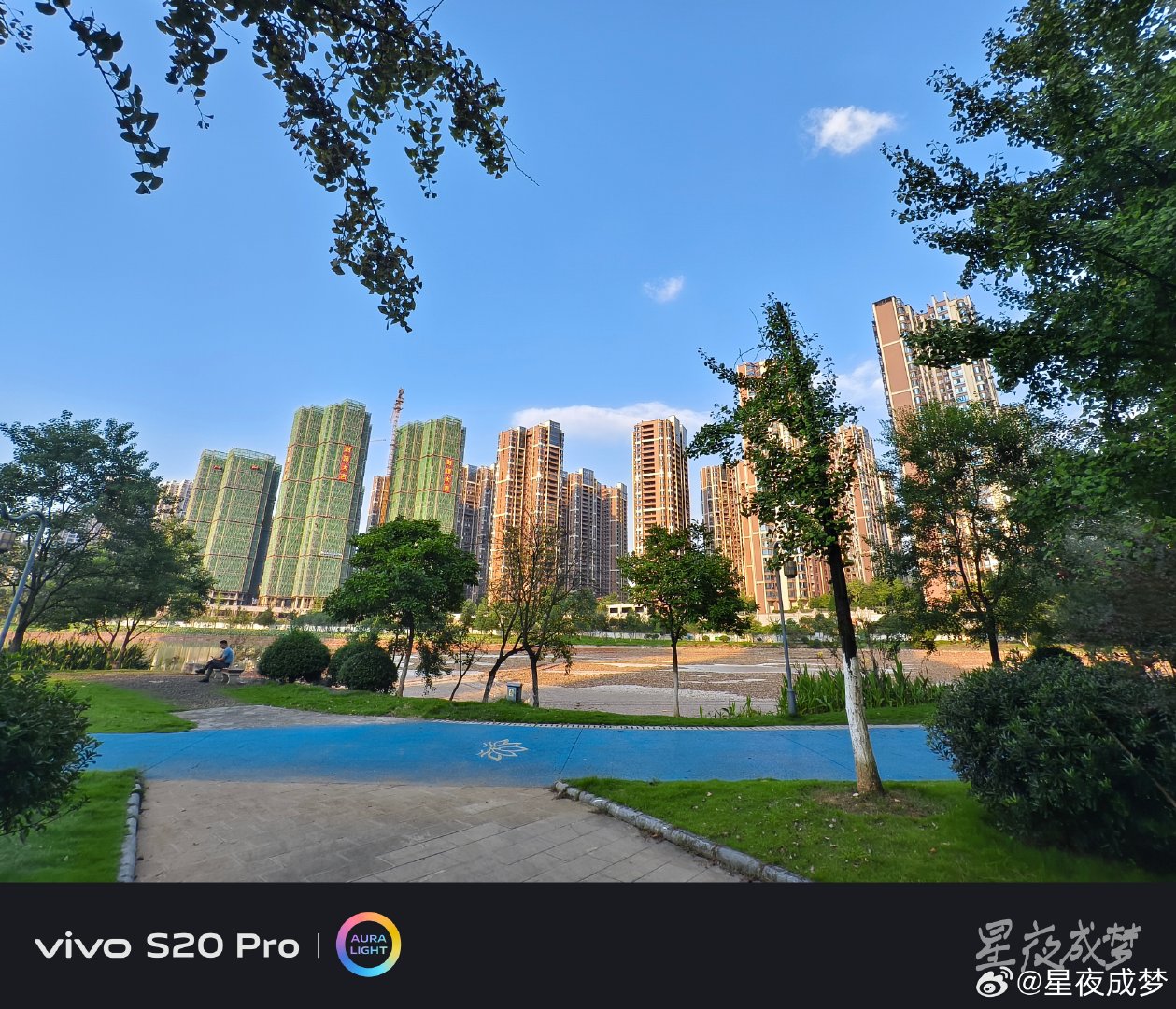 #vivo[超话]# 这条蓝色的步道在公园里蜿蜒延伸，远处的高层住宅群和在建楼盘构成了壮观的城市天际线，有人坐在长椅上休息，蓝天白云下一切都开阔又明亮，郴州的变化真大。vivo S20 Pro的广角镜头把视野拉得很开，步道的纵深感和远处的建筑都清晰可见，色彩通透，随手拍就是风景大片。#vivo##vivo超话# ​