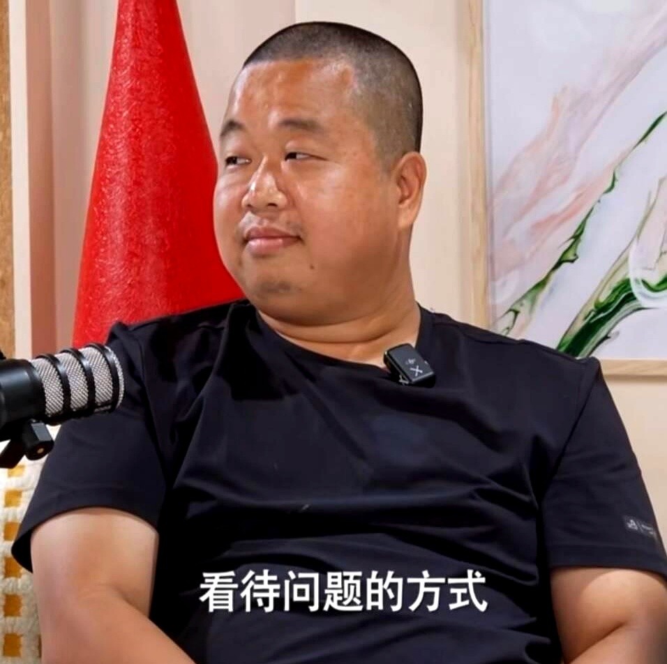 穿一身黑短袖黑短裤，脚踩人字拖，就敢直接坐到水均益对面接受访谈。

看着像个没文化的糙汉，一开口全场直接反转。从环游各国的见闻聊到对国内外的观察，再聊到对人生和生死的看法，水均益抛出什么问题他都能接住，好几个回答甚至让水均益当场露出意外的神情。

全程不怯场，聊得全是干货。很多人总觉得网红爆火全靠运