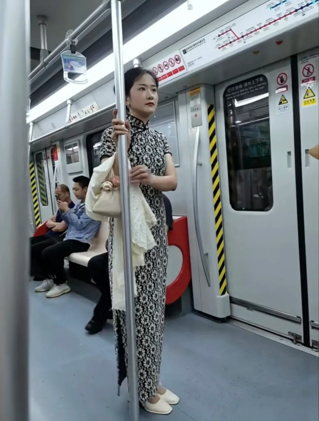 今天坐地铁出门去办事，在地铁上看见了一位穿旗袍的小姐姐。一身黑底白花的...