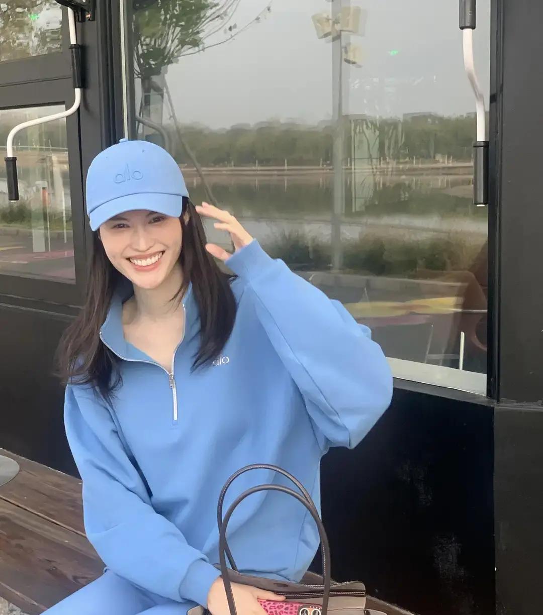 超模就是超模，随便套件宽松卫衣往街边一站，愣是把北京转瞬即逝的秋天拍出了电影质感。
何穗这次在社交平台上发出来的近照，真没整红毯上那些华丽繁琐的行头。
黑超遮面，头发随意散着，身后正好赶上一大片橘红色的傍晚晚霞。
普通人平时拍照总琢磨怎么找角度、怎么收下巴，生怕显胖显矮。
可你看超模随手抓拍