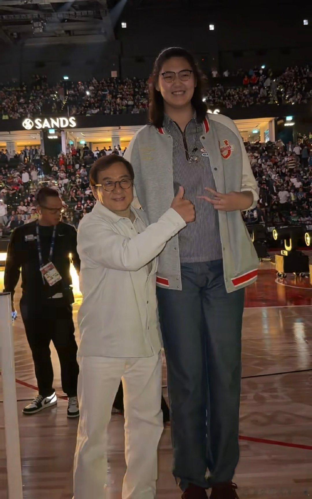 #成龙张子宇澳门NBA赛场同框##NBA中国赛#
澳门球馆内精彩不断，成龙到场观战，与女篮新星张子宇同框合影。跨越行业，大家都沉醉在篮球赛事的魅力之中。 ​