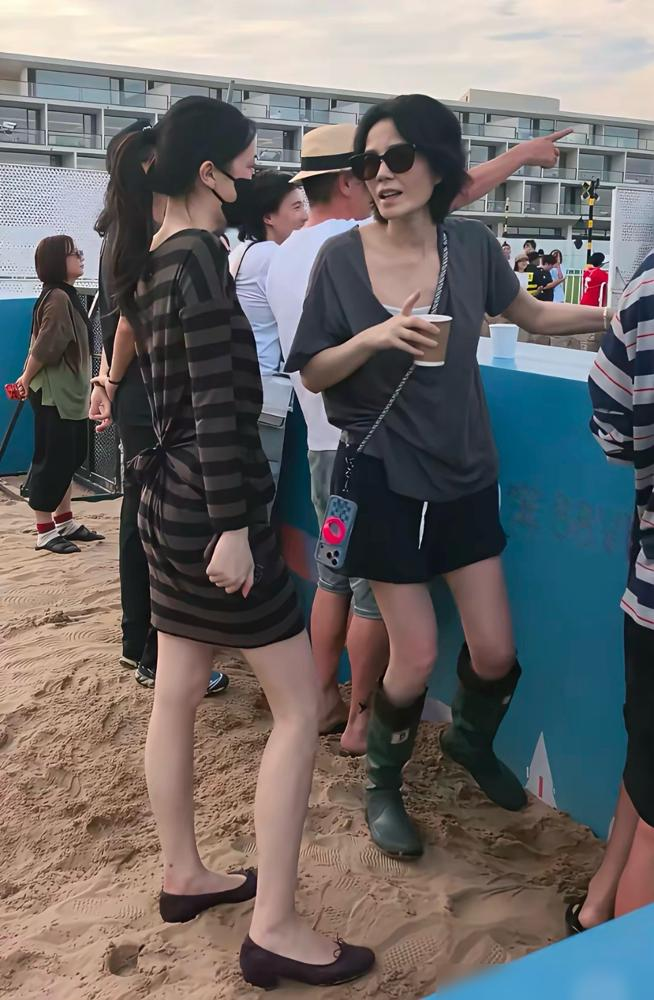 王菲在台下哭到擦鼻子，旁边李嫣没递纸，反而跟宋妍霏一起蹲地上了。
阿那亚音乐节，窦靖童连唱12首，压轴是写给王菲的《烟花》。王菲穿灰T恤黑短裤，素颜戴墨镜，混在VIP区跟着节奏晃。镜头扫到她时，她正抬手反复抹眼角，动作持续好几秒，不是擦汗。
更绝的是，大屏幕一切到观众席，王菲条件反射往朋友身后趴