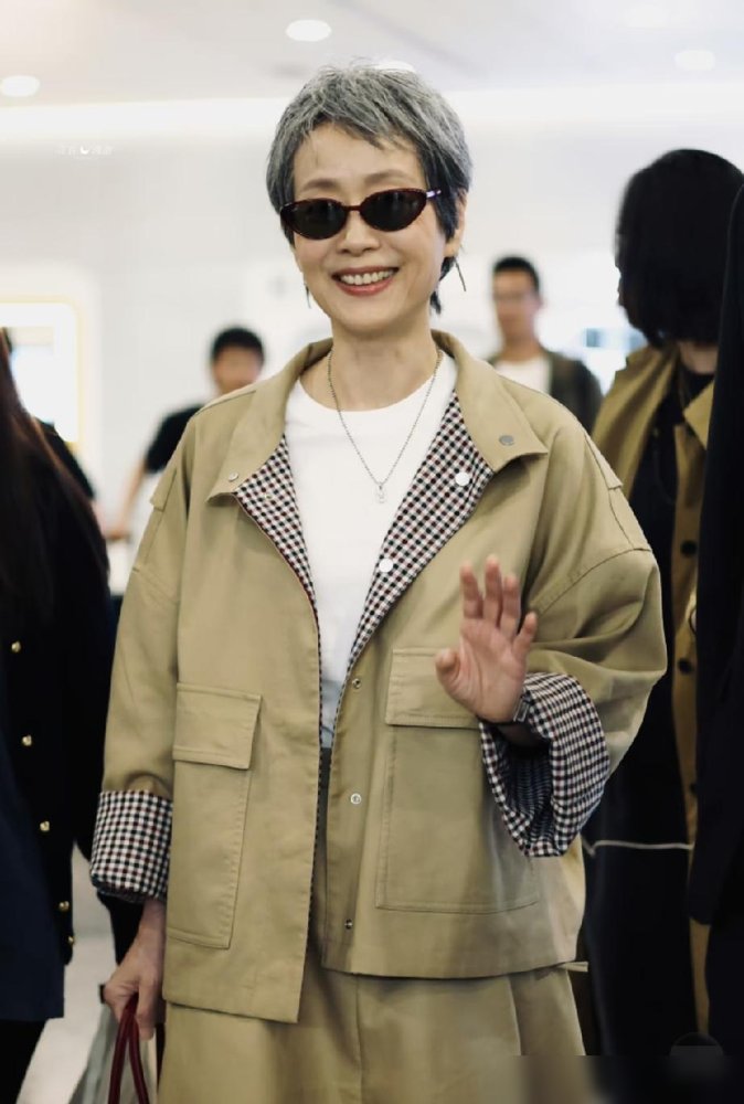 63岁了，叶童往机场一站，全网年轻人都闭嘴了。
卡其工装配一头白发，墨镜一戴，没硬凹少女感，也没穿成奶奶样。松弛，高级，走路带风。
想想她这几年，真没闲着。《寒战1994》里演方姐，转头又上《乘风2025》，跟GAI合唱《爱江山更爱美人》，台下粉丝激动得拉她手，她直接下车去抱人家。
别人怕老，
