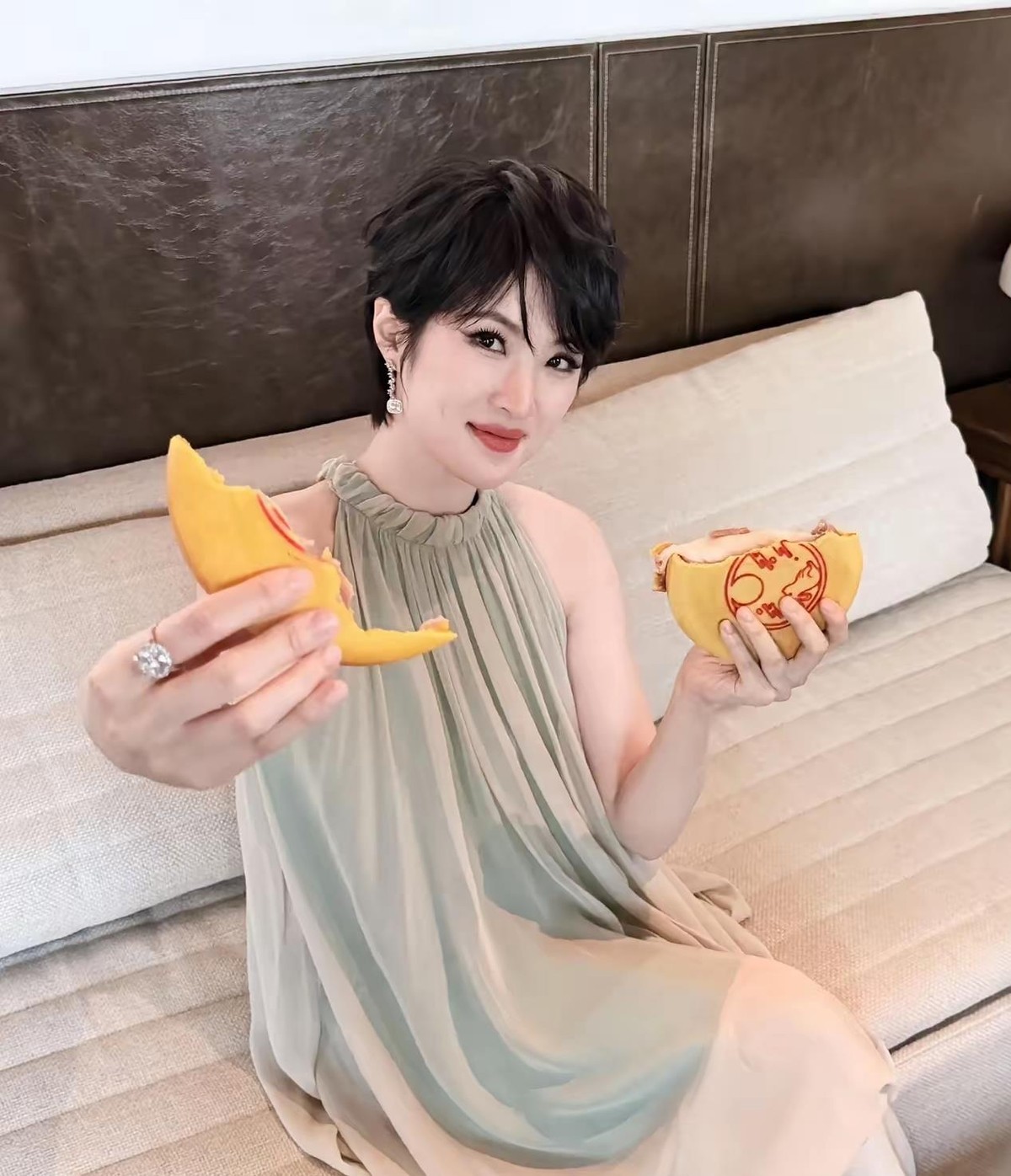 姚安娜中秋晒照，捧月饼的手上那枚钻戒比月饼还抢镜。照片里她短发配浅色挂脖长裙，手里举着迷你月饼，看着就是随手一拍的生活照，没刻意摆什么姿势。钻戒后来被扒出来是CRD的高珠系列，品牌方9月23号就发过她佩戴的官方动态，属于正经商业合作，估价大概在五六位数之间。有意思的是评论区，一拨人研究月饼什么馅儿，