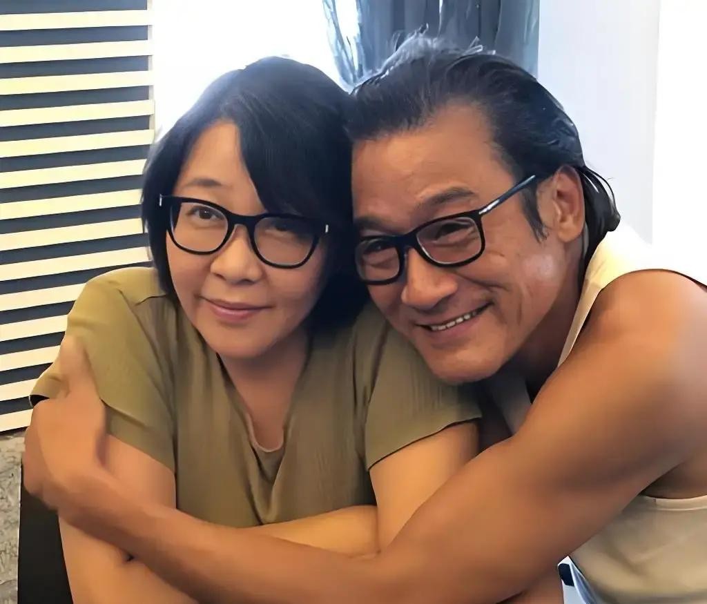 68岁的梁家辉在菜市场买菜，熟练地蹲下身给旁边身材发福的妻子系鞋带

很多网友看了抓拍的照片都在背后嘀咕，说这个连普通大妈都不如的女人，怎么配得上拿过四次金像奖的影帝

但那些敲键盘的人也许不知道，就是这个被外界嘲讽的“丑妻”，当年可是敢单枪匹马闯进黑帮堂口，硬生生把老公的命给抢回来的狠角色

上世