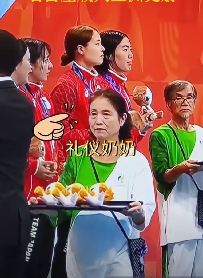 【一睹为快】
名古屋亚运会的颁奖礼仪环节打破了传统“青春靓丽礼仪小姐”的固有印象，现场大量银发老年志愿者承担了奖牌托盘递送等礼仪工作，其中不乏70岁以上的长者，甚至有80多岁的高龄参与者，被网友调侃为“银发礼仪大爷大妈”，成为本届赛事的独特画面。
