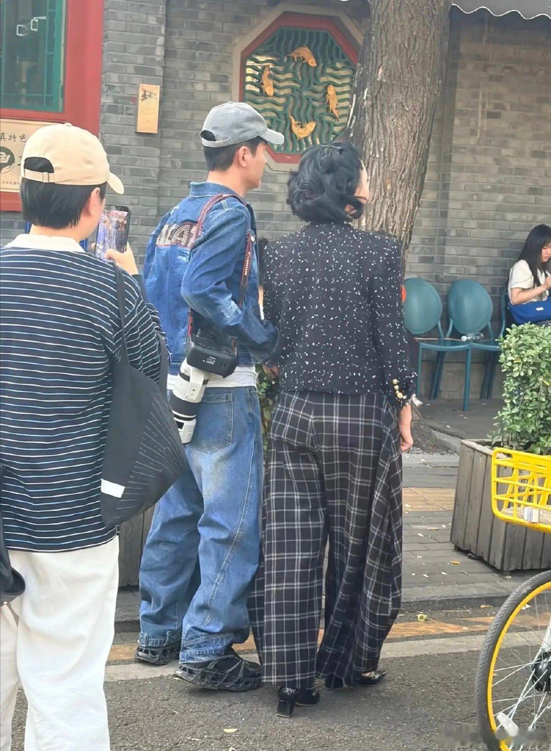 51岁郭晓东和老婆程莉莎在北京公园散步被偶遇，他背着一个长筒摄像机，在健身器械上锻炼，全程都很自然，完全不在意旁边路人的目光，实在太接地气了！ ​