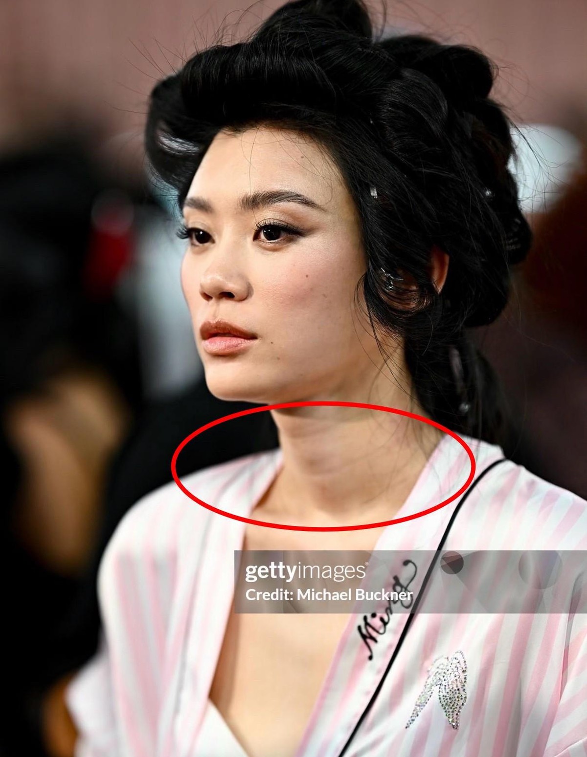 但就是这个颈纹去不掉的女人，2026年10月重新站上了维密T台。37岁，两个孩子。官方把她的第二套造型镜头切成慢动作，背后那对金色薄纱翅膀是当场翼展最大的。后台照片流出来，素颜，斑点看得见，颈纹也看得见，没有修图。
往前倒九年。2017年11月20日，上海维密大秀，奚梦瑶踩到纱裙跪倒在T台上，膝盖砸