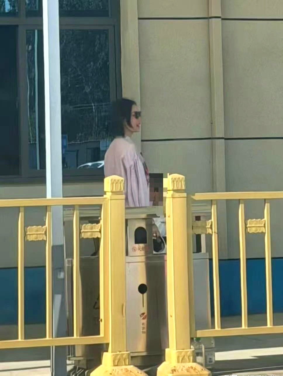 谁能想到平时红毯上大杀四方的冷艳女神，也得乖乖在烈日下死磕科目二。

粉色衬衫搭阔腿裤，素颜卡着个大墨镜，倪妮就这么钻进了教练车。方向盘一握，红毯女王瞬间变成战战兢兢的驾考人。

趁着教练下车的空档，她掏出手机冲镜头比了个大大的耶，咔嚓一张自拍。这松弛感，哪像来受折磨的，倒像来驾校体验生活的。

就
