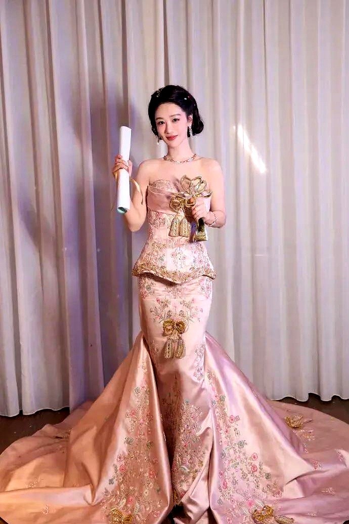 白玉兰红毯镜头扫过，杨紫硬生生把自己塞进那套修身裸粉高定里，腰线勒出一丝紧绷的局促。

为了撕掉贴了十几年的国民闺女标签，她这次拼了。作为首位提名视后的90后，这套新中式礼服就是她的投名状，她太想告诉所有人，小雪长大了。

裙子太挑身材，走动间略显吃力。一旁的梅婷顺势攥住她的手，两人并肩往前走。前辈