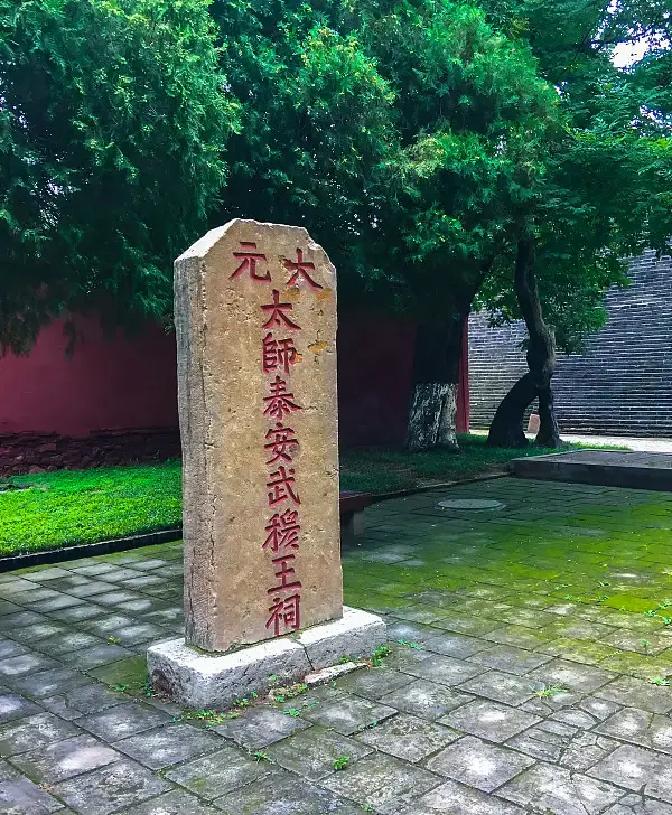 泰安岱庙边，立着一块红漆斑驳的碑，上面刻着“大元太师、武穆王祠”
施工队长老李蹲在碑前，指着一处新崩的缺口，脸色难看。旁边的工友嘟囔：“刚才铲车没留神，蹭了一下。这点小伤，应该不碍事吧？”
老李没接话，点了根烟。这块碑原来埋在上游双龙池的工地上，是他带人刨出来的。当时一铲下去，“哐当”一声响，震得人