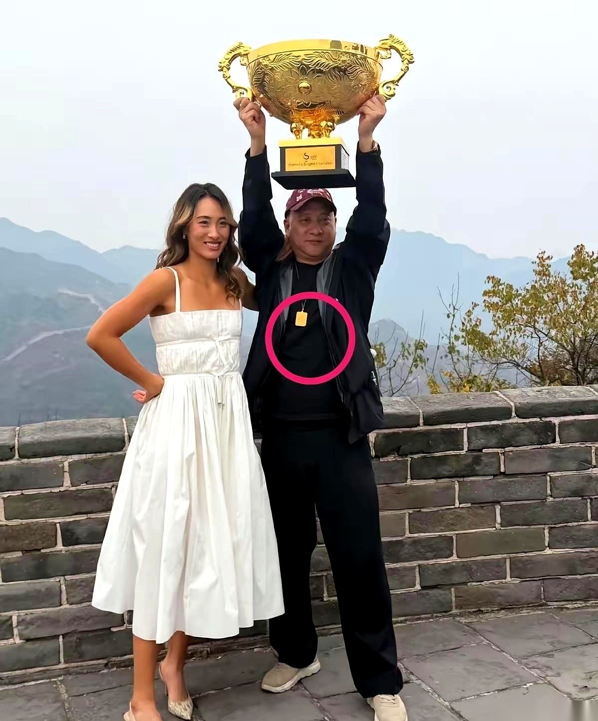 郑钦文一年赚一个多亿，全身上下都是奢侈品牌。
站在长城合照里的坪叔却只穿了一身黑衣黑裤，脖子上的“金牌”估计也就50克。
有网友正盯着看郑钦文到底买不买那套20万以上的顶级套装。
有些人的逻辑特别有意思。
一看到女儿成了世界冠军、赚了大钱，第一反应不是替人家高兴，而是低头去扫老爹身上的行头，算计这身