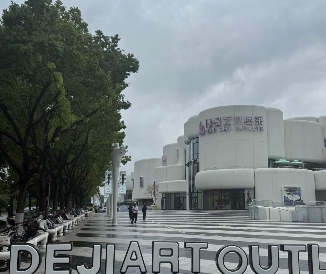 26号开业的仙林德基，我赶在大雨天去凑了个热闹，结果逛了十分钟就想往外跑。

现场人确实不多，外面哗哗下大雨，门口也没排起长队，看着多少有点“先开业后补作业”的感觉。

外立面白白的，远看像童话盒子，旁边就是羊山湖公园，水景一借，拍照挺有氛围。

一进门还是熟悉的德基味，颜色铺得满，商品也琳琅满目，