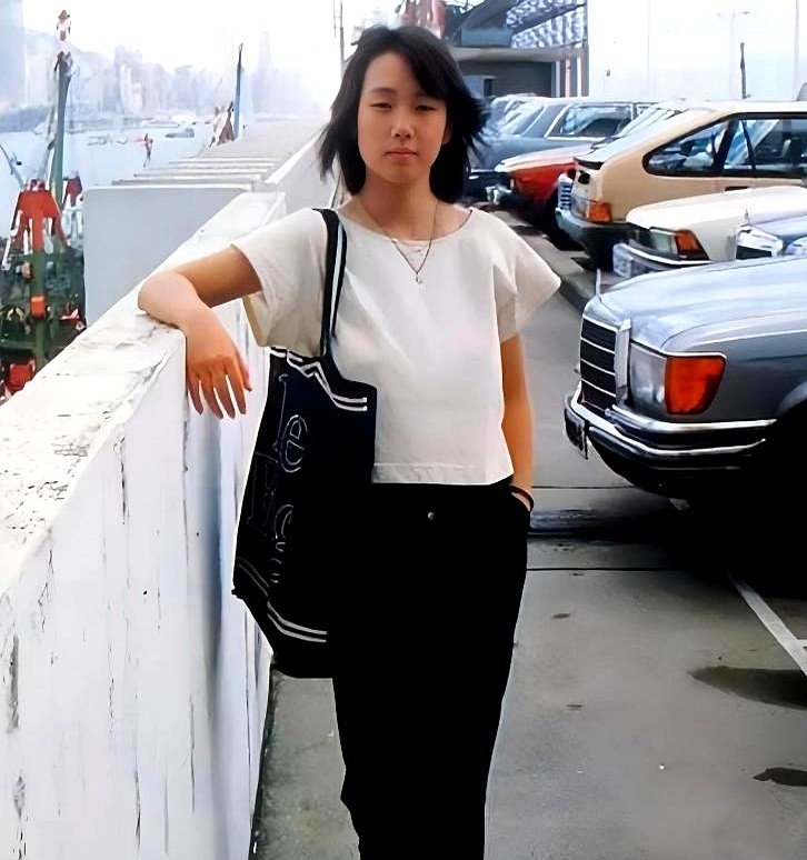 18岁的林忆莲站在尖沙咀停车场，没化妆，也没开任何滤镜。

这组抓拍旧照最近突然火了。照片里的她，一双标志性的小眼睛，眼型细长。

放在当年那个偏爱浓眉大眼的时代，这张脸绝对算不上标准。

但她就是特别。不笑的时候透着点距离感，一弯起嘴角，又让人觉得很暖。那时候的港圈，美得千姿百态，谁也不像谁。