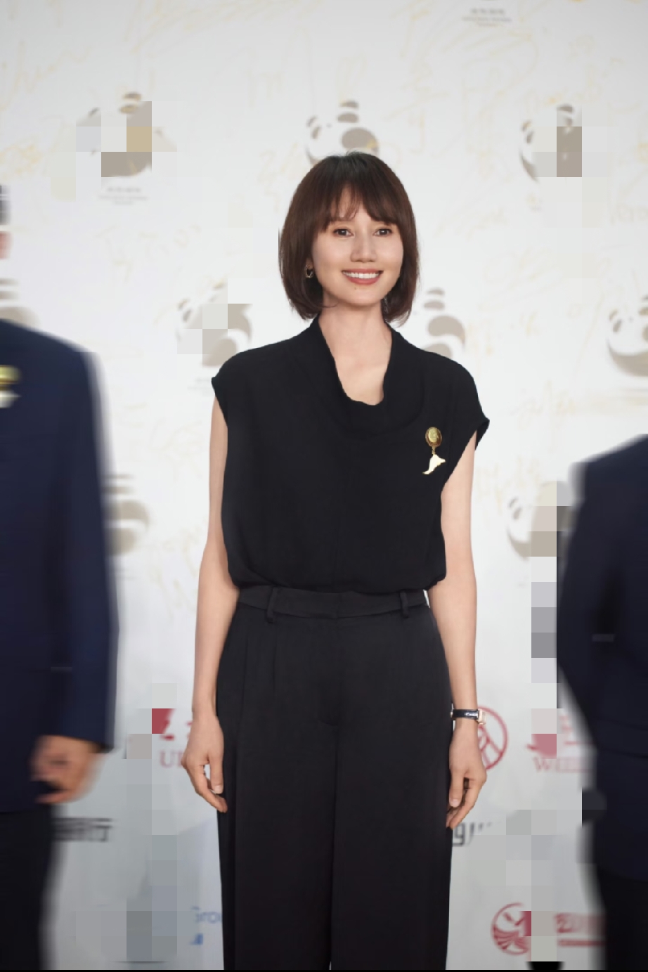 袁泉这套全黑极简造型把高级感刻进骨子里，无袖垂感上衣配阔腿西裤，胸针做点缀，短发利落笑容舒展，尽展熟龄女性从容通透的优雅质感。