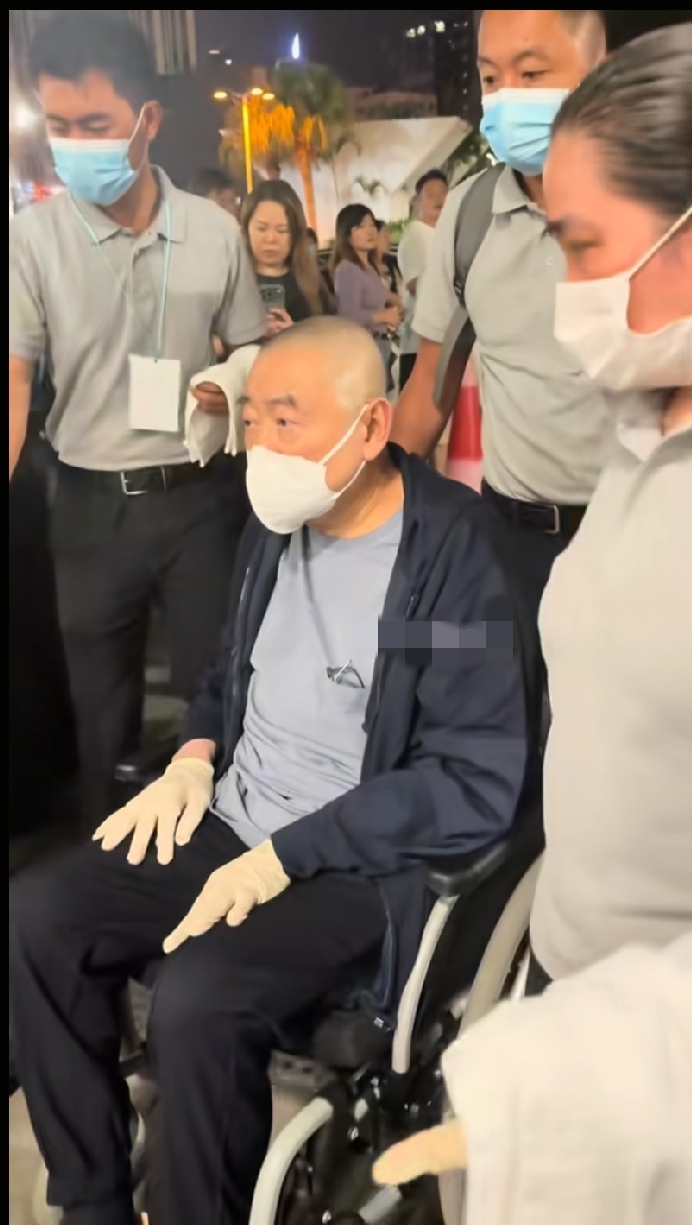 刘銮雄现身谭咏麟香港红馆演唱会时的一幕，身边的工作人员都戴着口罩和橡胶手套。