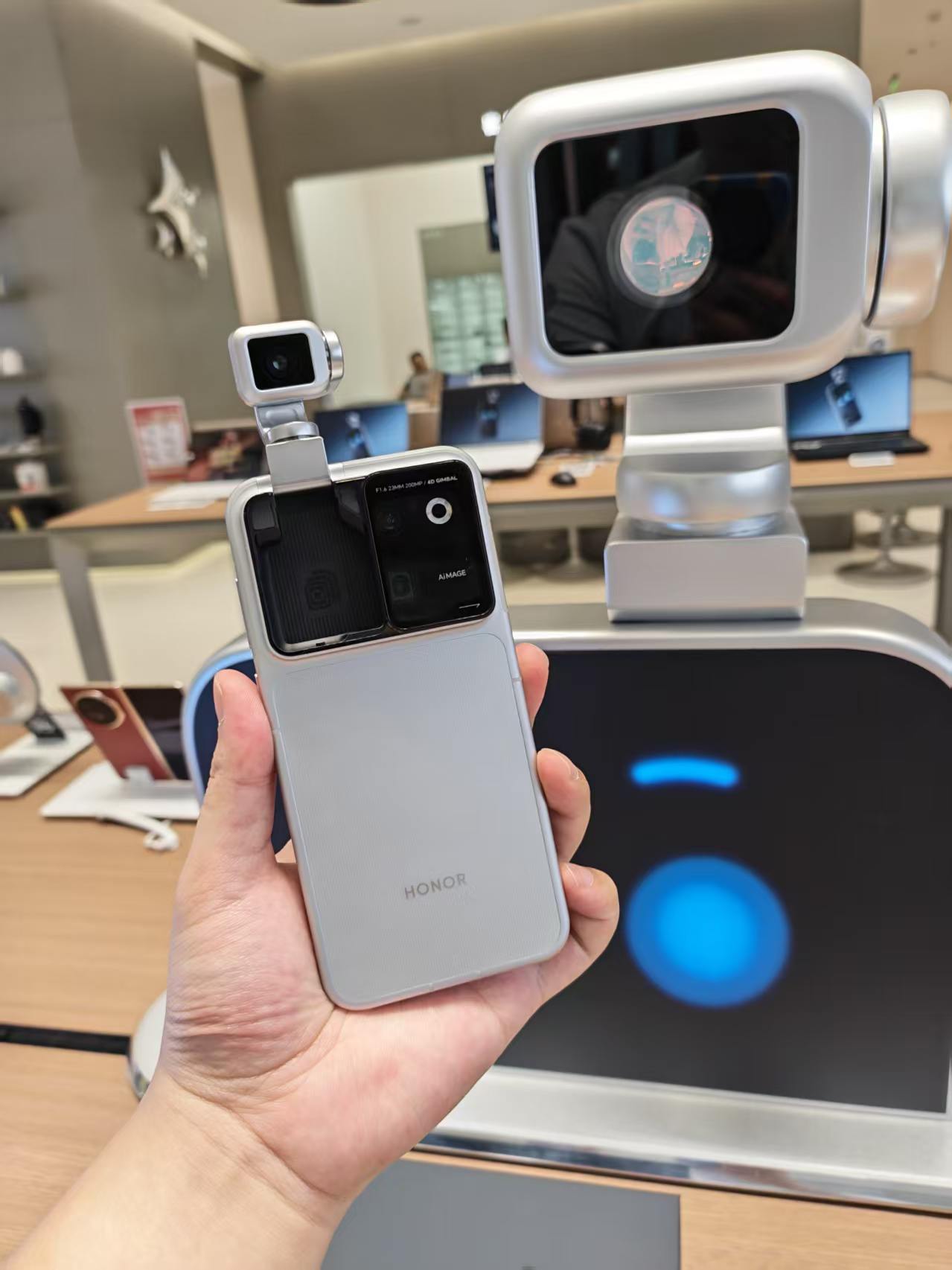 荣耀最新的机器人手机Robot Phone来了！
最厉害就是这个可以弹出来的钛合金灵巧云台，可以自由旋转，自动跟踪拍摄对象，拍视频直接自带稳定器。
和阿莱合作的电影影像，拍出来视频特别有质感。
还有超有意思的YOYO机器人模式，云台会跟着音乐跳舞、点头互动。
想感受未来手机是什么样子，可以来店里体验