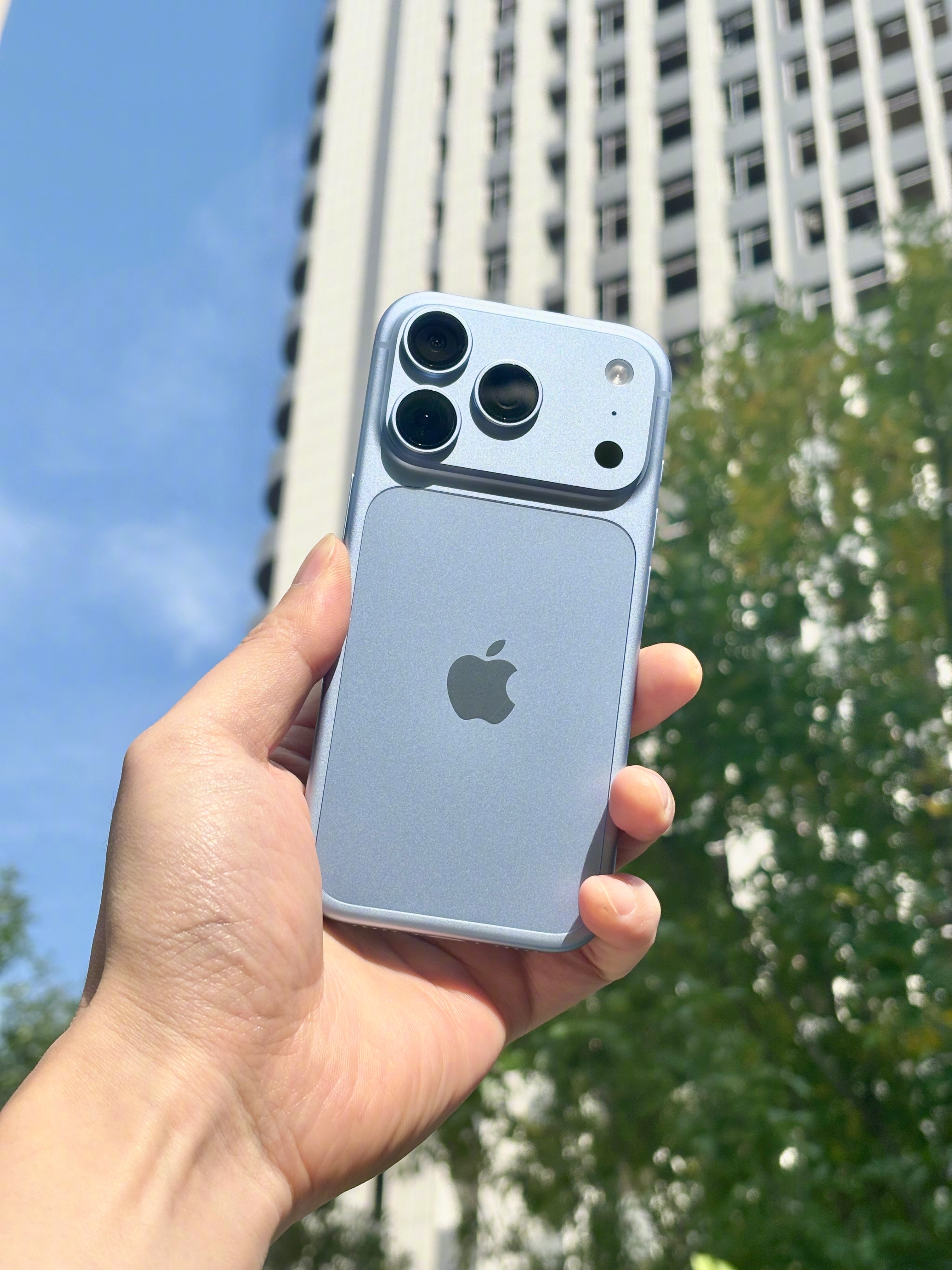 迎着阳光拍了几张iPhone18 Pro冰川蓝。
铝合金一体成型，整机的一体感确实做得很好。但实话讲，单论视觉层次感，我还是觉得玻璃后盖会更高级。
两种材质各有取舍：玻璃好看通透，可惜摔了容易碎后盖；铝合金摔了大概率只是变形，不会直接碎裂，起码不影响正常使用。没有绝对完美的方案，看你更看重哪一 ​