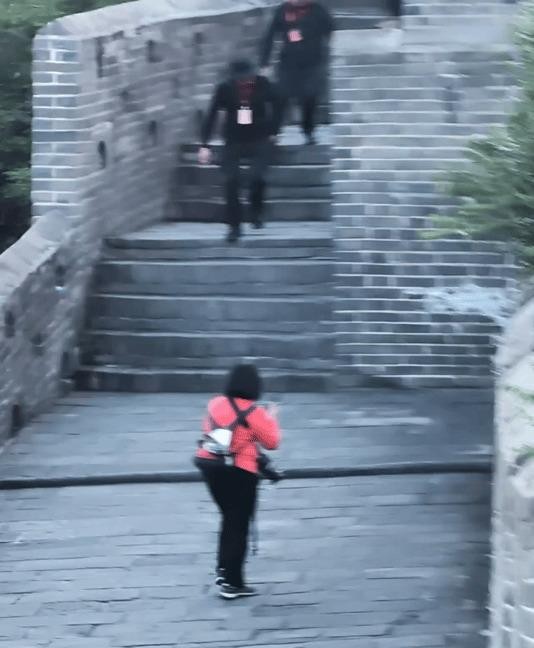 金山岭的秋风撞在城砖上，肖战一身中山装立在垛口边，风灌进衣袖，身形没动过分毫。 游客隔着几步远举着手机，画面模糊，那股板正劲儿却透得清楚。 有人小声哼了句旋律，他侧头笑了笑。 这片城墙见过太多意气风发——几年前肖春生站在这儿喊“今日长缨在手”的时候，也是这样的风，这样的挺拔。 歌声一起，山河当背景，