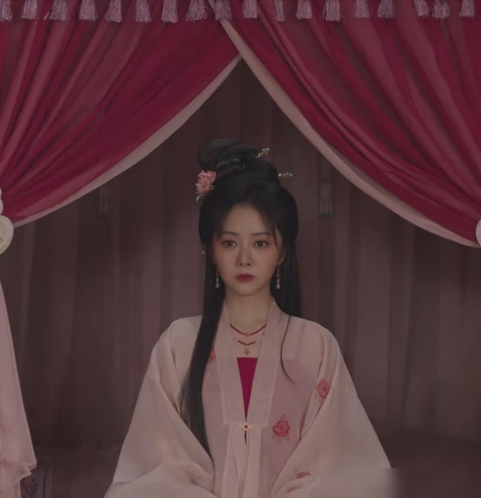 谭松韵那件粉衣服，一脱下来，刘美含接过去穿上，弹幕直接炸了。
剧里许兰香和吕蕺儿互换外衣，粉蓝撞色一上身，一个像沾着晨露的杏花，一个像绷在弓弦上的绸缎。镜头扫过绣花鞋尖，再扫过领口蹭着粉底的边，谁赢谁输，根本不用台词。
谭松韵前期的浅杏水蓝，是养在深闺的嫩；被踩进泥里那几集，灰褐土黄粗得扎眼，愣