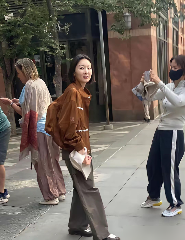 周冬雨在纽约地铁口被堵了，没墨镜没保镖，就穿件皱巴巴的灰外套站那儿，脸都没洗。
镜头怼到跟前，她也没躲，还乐呵呵跟路人聊了两句。那皮肤状态，暗沉是暗沉，但就是透亮，巴掌大的脸，搁人堆里像个刚下课的学生。
搁以前，这画面你敢想？谋女郎出道，红毯上哪次不是绷着。现在倒好，直接素着逛曼哈顿，坐地铁，排
