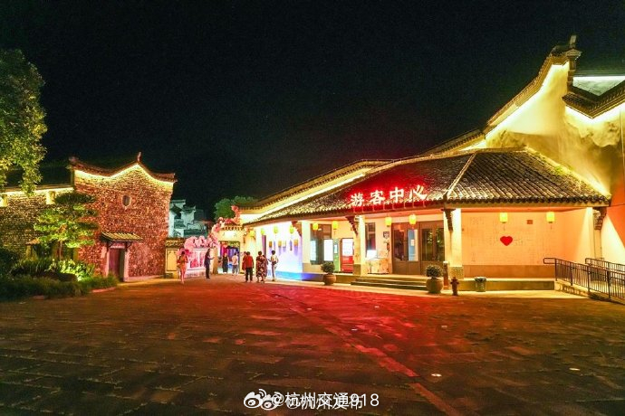 【#国庆杭州自驾可达的古镇推荐#】近日，杭州龙门古镇换上“夜景新装”。石塔山上灯光次第亮起，同兴塔在光影中如水墨写意。龙门溪、剡溪两岸灯带顺水蜿蜒，步步皆景。古建筑群被暖光勾勒出木构肌理，老街青石板路灯火蜿蜒，与窗棂微光呼应。砚池边，暖红灯笼与粉墙黛瓦相映。千年古镇的夜色，很有味道 ​