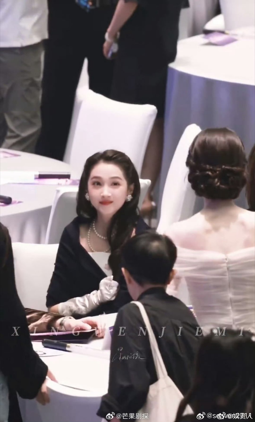 娜扎关晓彤挑眉打招呼成为湾区升明月晚会名场面。晚会内场娜扎入场路过关晓彤身旁，二人对视，关晓彤俏皮挑眉回应，娜扎温柔浅笑，互动自然松弛，全无刻意营业。这一幕打破过往两人不和的传闻，尽显同龄女星之间惺惺相惜的善意。当晚造型黑白呼应，关晓彤黑裙优雅灵动，娜扎白裙仙气舒展，气质互补。没 ​