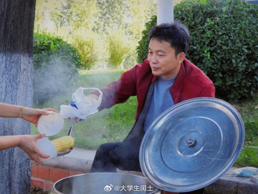 齐鲁师范学院教授迎新现场煮自己培育的玉米送给新生。 ​​​