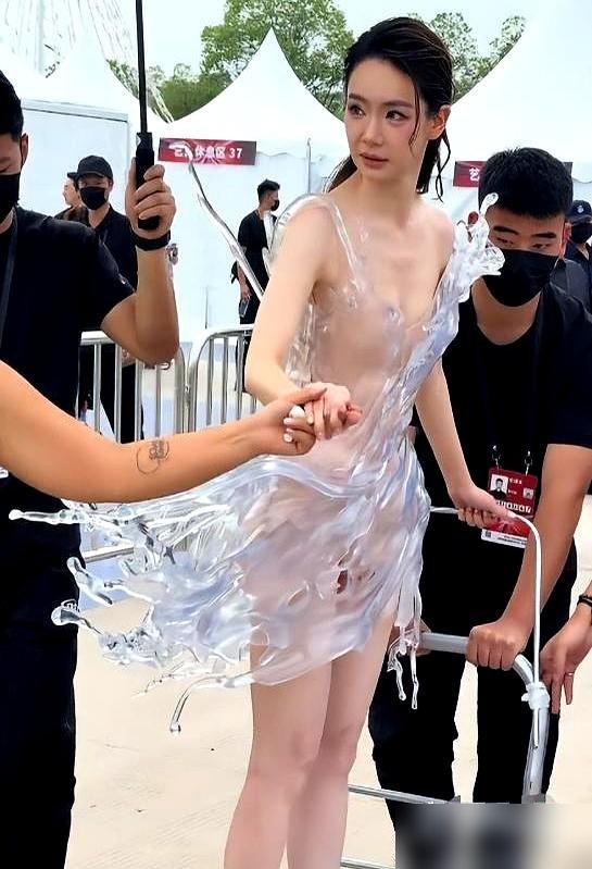 41岁，32斤，裙子重到要人用板车推上红毯。
戚薇这身3D打印“水花裙”，硬得弯不了，坐不下，走不动。她自己说，胖一点穿不上，瘦一点挂不住。当天还在做根管治疗，牙疼着被推上场。
就为了那几十秒镜头。热搜是有了，人也像个展品。
之前她卖AI脸，说“没必要装清高”，现在又把自己塞进32斤塑料壳里。