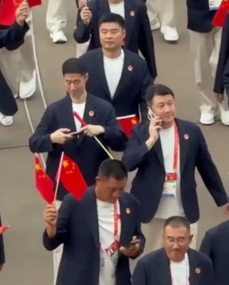 王励勤代表国乒参加开幕式，挺帅[赞]
亚运会开幕式上，没有见到国乒的王楚钦，孙颖莎，王曼昱他们。
因为，明天乒乓球团体赛就要开打，所以大头莎莎们都在加紧备战训练，做最后的冲刺！
在代表团的队伍中，看到了王励勤主席。
王主席一身深色西服，白色裤子，挥舞着五星红旗，帅帅的，松弛感拉满！
不时用手机拍下这