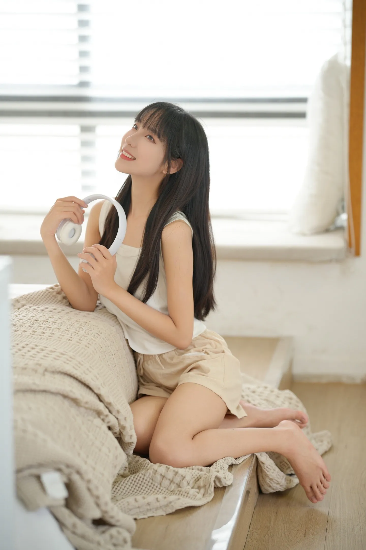 阳光洒满房间，少女戴上耳机，享受音乐时光。 甜妹